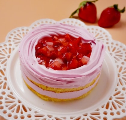 いちごのホールケーキが白いレース調のお皿に乗っている画像