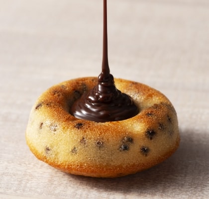 焼き菓子にチョコレートを垂らしている画像
