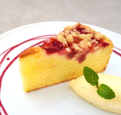 バニラアイスが添えられたベリーの乗ったケーキが白いお皿に乗っている画像